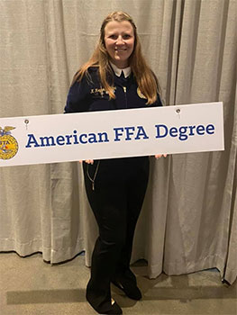 Kayleigh holding sign that says American FFA Degree